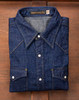 Folded blue denim shirt on a wooden surface