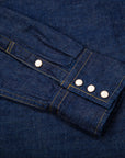 Close-up of blue denim fabric with buttons and stitching details