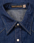 Close-up of a blue denim shirt collar with a brand label.