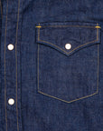 Close-up of a blue denim shirt with a pocket and buttons.