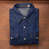 Folded blue denim shirt on a wooden surface